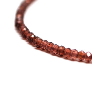 A garnet microbead necklace against a white background