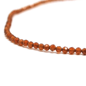A hessonite garnet microbead necklace against a white background