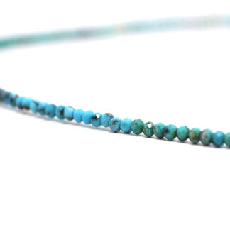 A turquoise microbead necklace against a white background