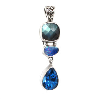 A sterling silver pendant featuring a square faceted labradorite, an Australian opal cabochon, and a teardrop faceted blue topaz gemstone with an ornate bail against a white background