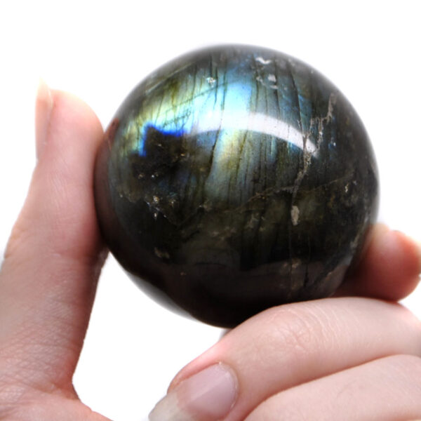 A labradorite sphere with blue tones against a white background