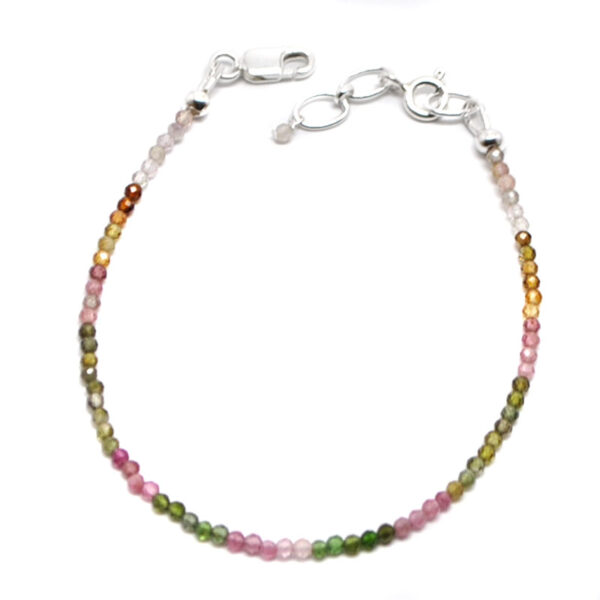 A mixed tourmaline microbead bracelet featuring pink, orange, red, and green tones with a sterling silver lobster claw clasp against a white background