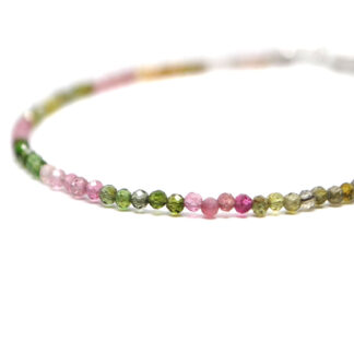 A mixed tourmaline microbead bracelet featuring pink, orange, red, and green tones with a sterling silver lobster claw clasp against a white background