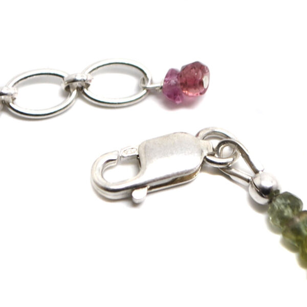 A multi colored tourmaline microbead bracelet featuring pink, blue, and green tones with a sterling silver lobster claw clasp against a white background