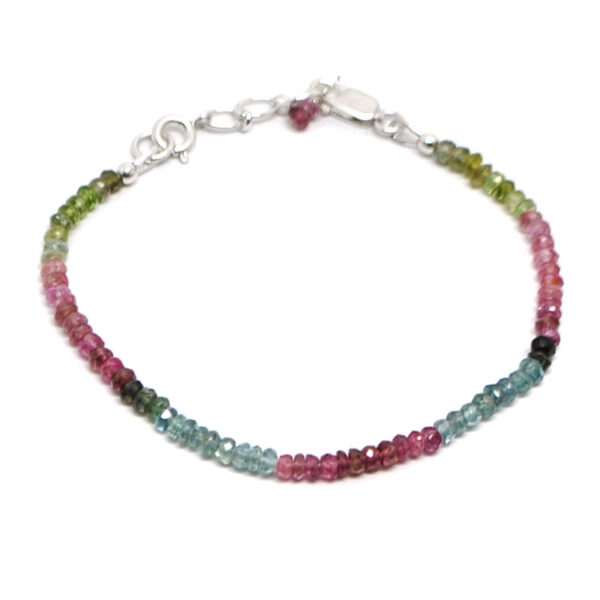 A multi colored tourmaline microbead bracelet featuring pink, blue, and green tones with a sterling silver lobster claw clasp against a white background