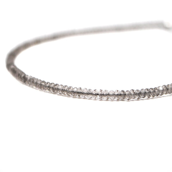 A smokey quartz microbead bracelet against a white background