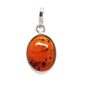 A polished piece of amber fastened with a sterling silver bail against a white background