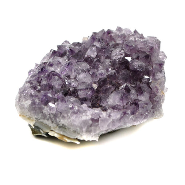A deep purple amethyst crystal cluster from Uruguay against a white background