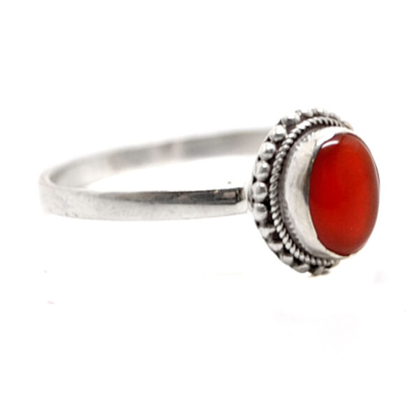 A sterling silver ring featuring a deep orange oval shaped carnelian stone against a white background