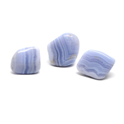 A set of three blue lace agate tumbled stones against a white background