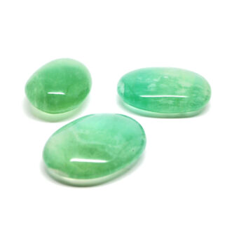 Three vibrant green fluorite palm stones against a white background