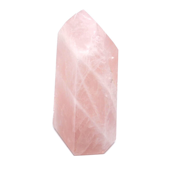 A piece of pink rose quartz that has been cut and polished into a tower against a white background