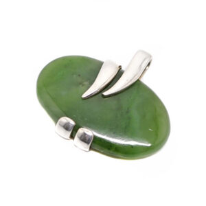 An oval dark green jade cabochon set into a wrapped style sterling silver pendant against a white background