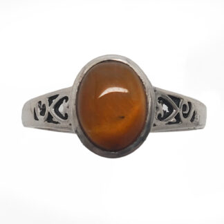 An oval tiger's eye cabochon set into a decorative sterling silver ring against a white background