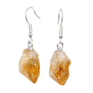 A pair of citrine crystal earrings with simple ear hooks against a black background