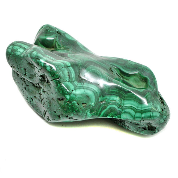 A polished free form green malachite specimen with defined banding against a white background