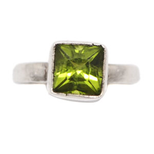 A sterling silver ring set with a square faceted peridot gemstone against a white background