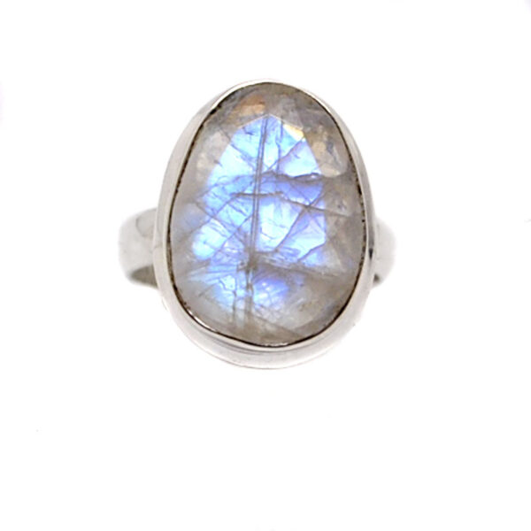 An oval rainbow moonstone cabochon set into a simple sterling silver ring against a white background