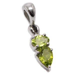 A sterling silver pendant prong set with two faceted peridot gemstones, one oval shaped and one teardrop shaped, against a white background