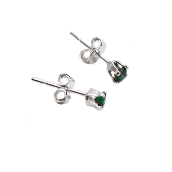 A pair of sterling silver stud earrings prong-set with round faceted emerald gemstones against a white background