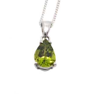 A sterling silver pendant prong-set with a teardrop faceted peridot gemstone against a white background