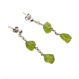 A pair of sterling silver post earrings featuring two rough peridot gemstones chained together against a white background