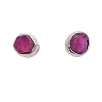 A pair of sterling silver stud earrings set with rough ruby crystals against a white background