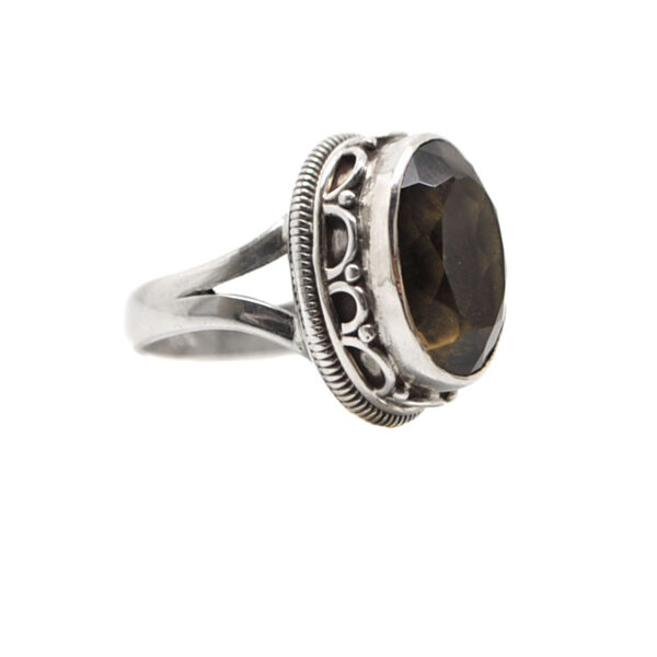 A sterling silver ring with a decorative bezel set with an oval faceted smokey quartz gemstone against a white background