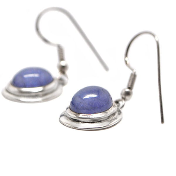 A pair of sterling silver dangle earrings set with oval tanzanite gemstones against a white background