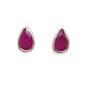 A pair of sterling silver stud earrings set with teardrop faceted ruby gemstones against a white background