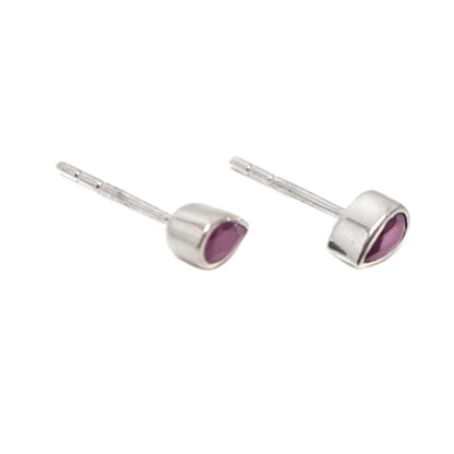 A pair of sterling silver stud earrings set with teardrop faceted ruby gemstones against a white background