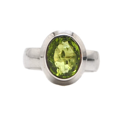 a ring with an oval faceted peridot set in sterling silver