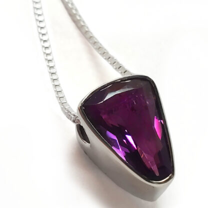 Amethyst Faceted Sterling Silver Pendant with chain against a white backround.