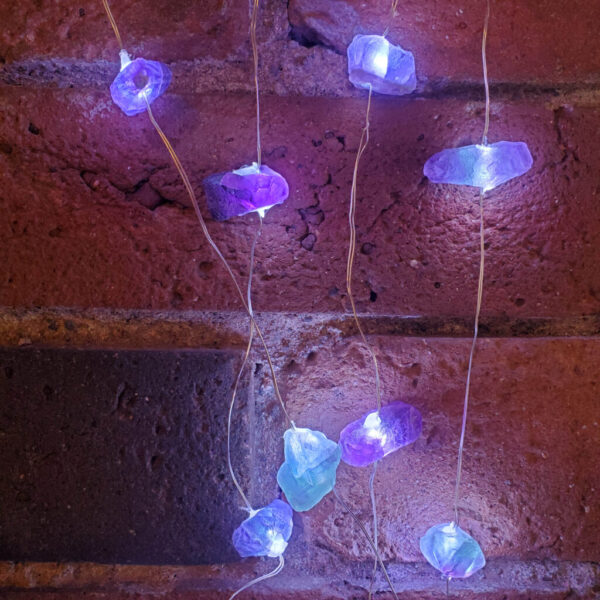 Fluorite LED String Fairylights turn on against a brick backround.