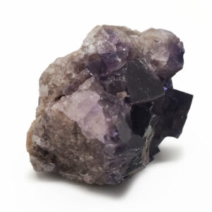 Medium purple fluorite cluster against a white backround.