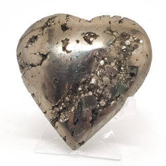 A carved pyrite heart carving with exposed crystals on a clear stand against a white background