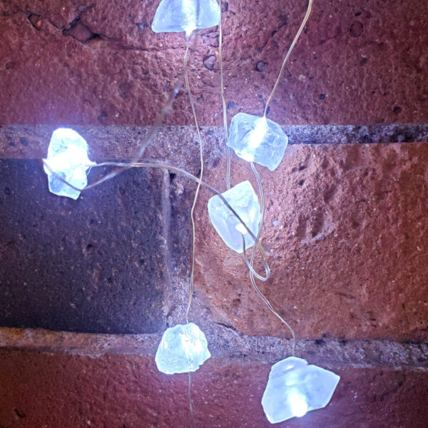 Quartz LED String Fairylights turn on against a brick backround.
