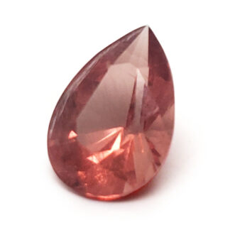A faceted sunstone cut into a tear-drop shape photographed behind a white background