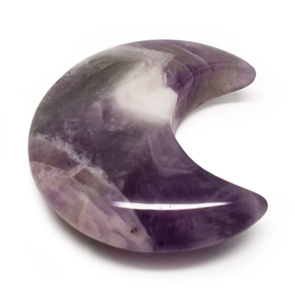 A carved amethyst moon cresent against a white background