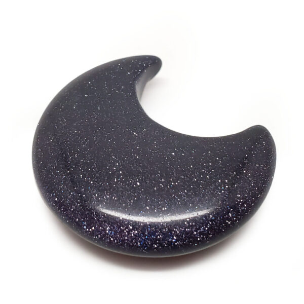A carved blue gold-stone moon cresent against a white background